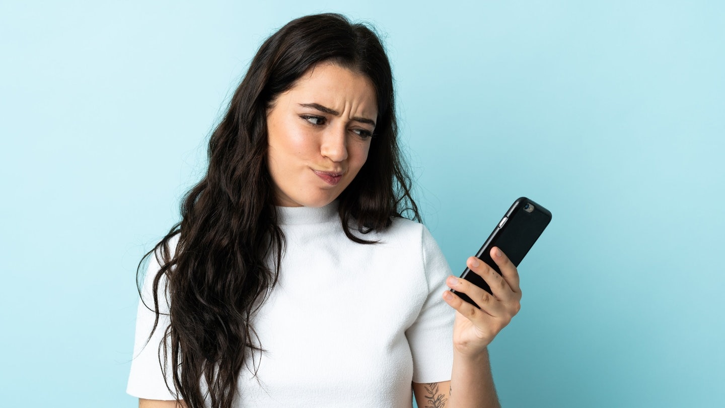 Frau versucht mit dem Telefon einen Arzttermin zu bekommen (Symbolbild) (Foto: Adobe Stock, luismolinero)