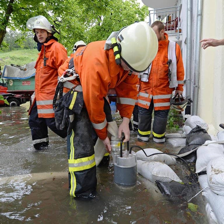 Feuerwehrleute helfen dabei, Hochwasser abzupumpen