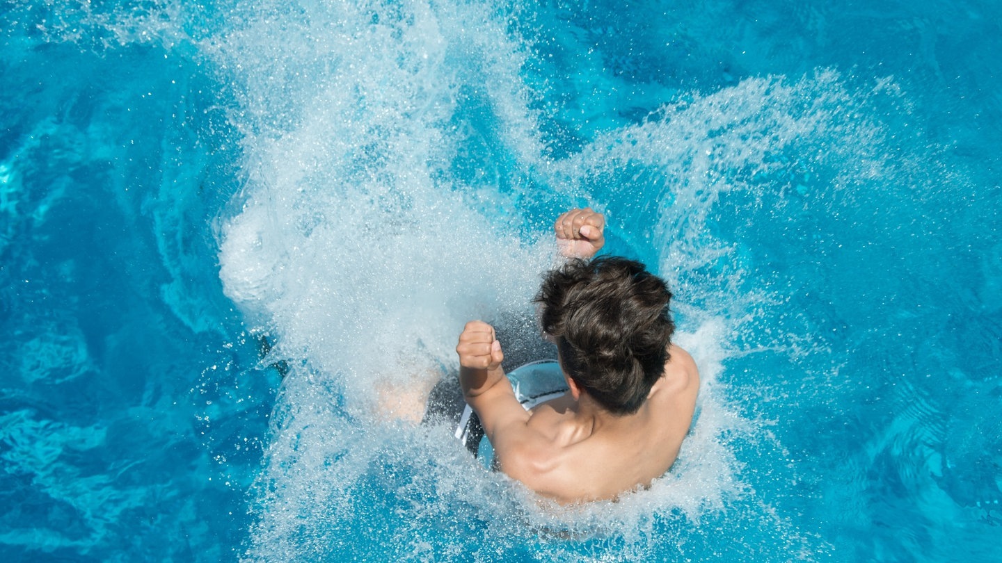 Hitze im Sommer: Ein Mann springt von einem Sprungturm in ein Schwimmbecken. (Foto: dpa Bildfunk, picture alliance/dpa/dpa-Zentralbild | Sebastian Kahnert)