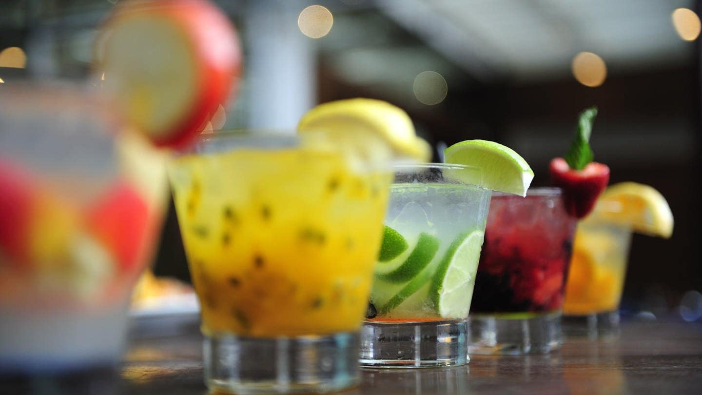 Fünf Gläser mit sommerlichen Getränken stehen auf einem Tresen