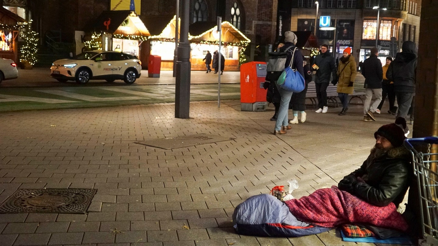 Kältebusse sind im Winter überlebenswichtig für viele Obdachlose. Obdachloser sitzt auf der Straße am Weihnachtsmarkt. (Foto: picture-alliance / Reportdienste, picture alliance)