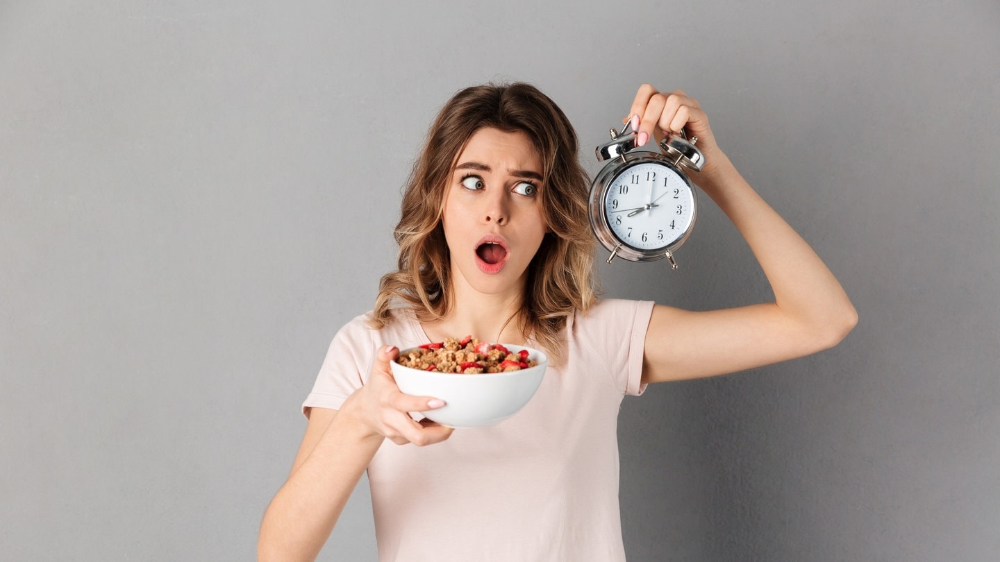 Eine Frau hat eine Uhr in der Hand, damit sie weiß, wann sie essen darf, da sie Intervallfasten macht, um abzunehmen. Wie klären, ob Intervallfasten eine gute Alternative zur klassischen Diät sein kann. (Foto: IMAGO, Pond5 Images)