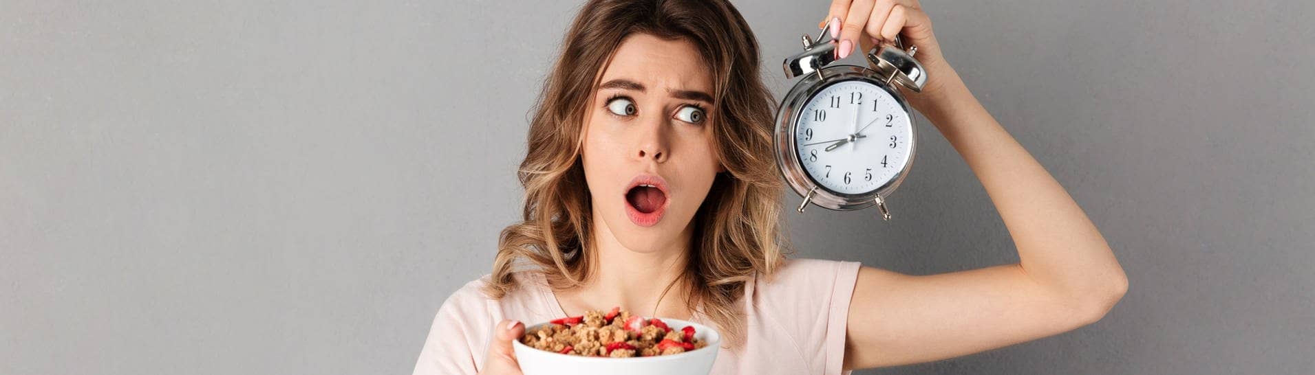 Eine Frau hat eine Uhr in der Hand, damit sie weiß, wann sie essen darf, da sie Intervallfasten macht, um abzunehmen. Wie klären, ob Intervallfasten eine gute Alternative zur klassischen Diät sein kann. (Foto: IMAGO, Pond5 Images)