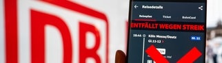 Im Hintergrund ist ein Zug zu sehen, im Vordergrund die Bahn-App mit dem Hinweis, dass der Zug wegen Streik ausfällt. Die GDL hat zum Bahnstreik aufgerufen. Im SWR3-Interview schildert ein Lokführer aus Köln exemplarisch seine Situation