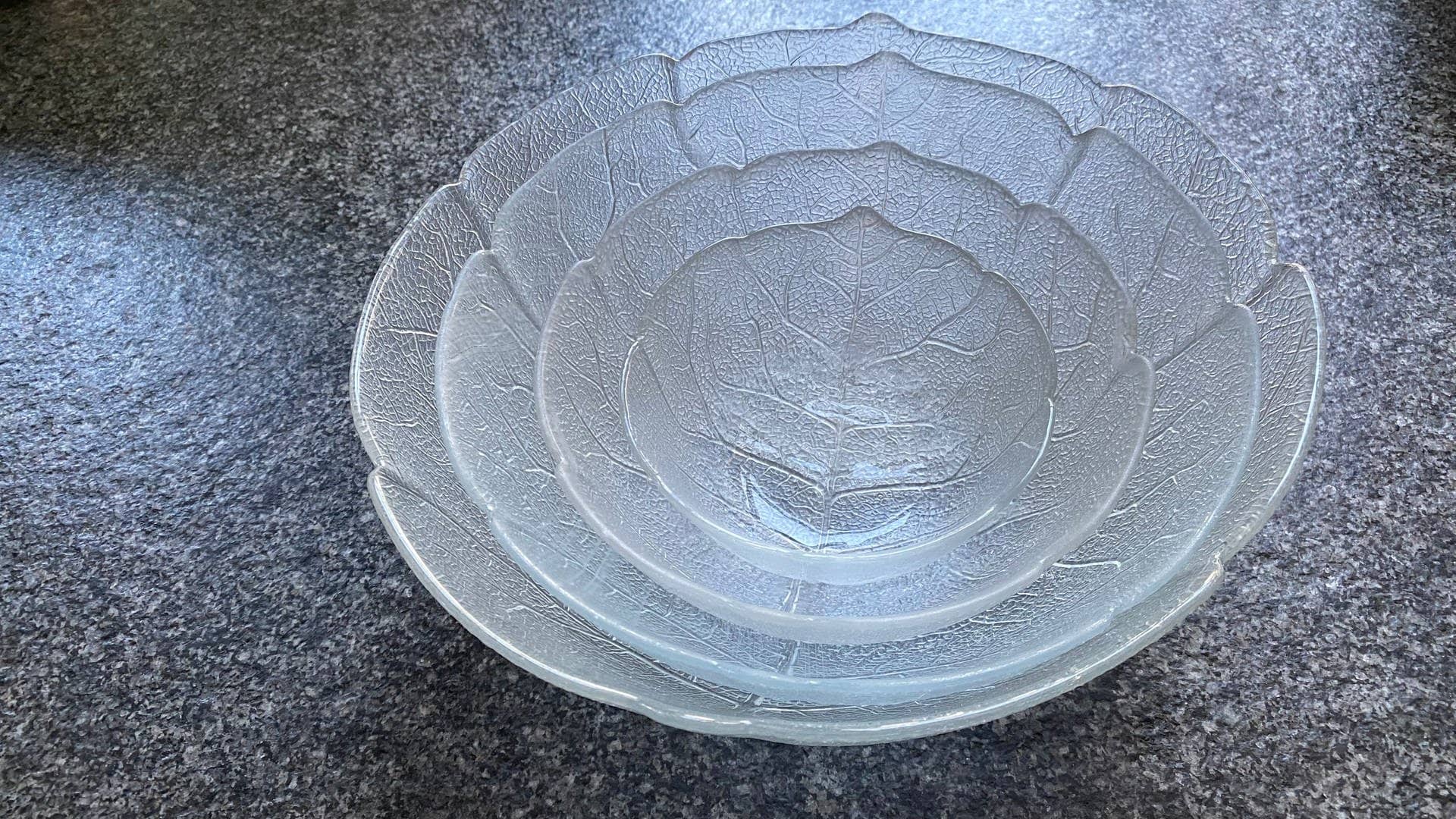 Mehrere Glasschalen mit Blattmotiv und verschiedenen Größen sind ineinander gestapelt. Diese Glasschüssel mit dem Blättermotiv kennt fast jeder. Aber warum sind die Schüsseln aus der „Aspen“-Serie so ein Erfolg und woher kommt die „Blattschüssel“?