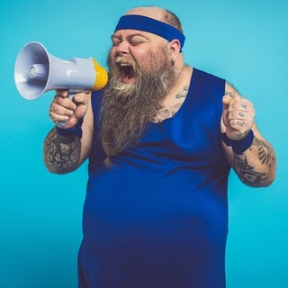 Mann im Trainingsanzug und Megaphone. Bauchfett verlieren: Mit diesen 3 Tipps wirds einfacher!