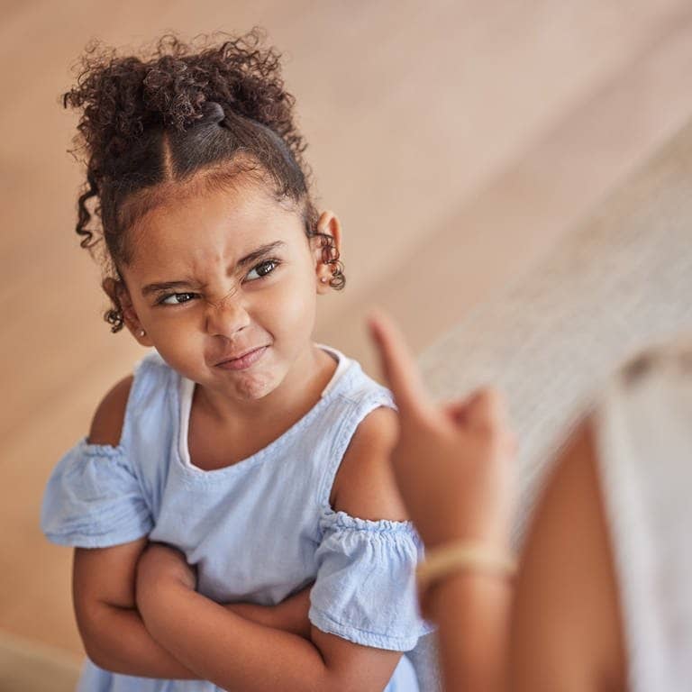 Ein Kind schaut zu einem erhobenen Finger. Wie wir fremde Kinder maßregeln können, verrät uns eine Familienexpertin