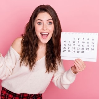 Junge Frau mit Kalender in der Hand. Symbolbild für Brückentage und Feiertage in 2025 – clever den Urlaub planen!
