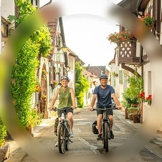 Ein Mann und eine Frau fahren auf den E-Bikes aus dem SWR3 Gewinnspiel der SWR3 E-Bike-Challenge durch SWR3Land und genießen den Frühling.