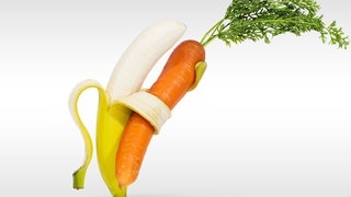 Banane umarmt Karotte. Symbolbild für den Unterschied zwischen Obst und Gemüse.