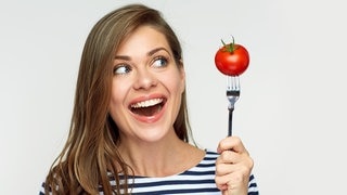 Junge Frau schaut erstaunt auf eine Tomate, die sie auf die Gabel gespießt hat. Symbolbild für den Unterschied zwischen Obst und Gemüse. (Foto: Adobe Stock, Yuriy Shevtsov) Junge Frau schaut erstaunt auf eine Tomate, die sie auf die Gabel gespießt hat. Symbolbild für den Unterschied zwischen Obst und Gemüse.