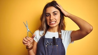Frau mit Schere und in der Kleidung einer Friseurin. Symbolbild für typische Sprüche vom Friseur, die Kunden nicht hören wollen. (Foto: Adobe Stock, Krakenimages.com) Frau mit Schere und in der Kleidung einer Friseurin. Symbolbild für typische Sprüche vom Friseur, die Kunden nicht hören wollen.