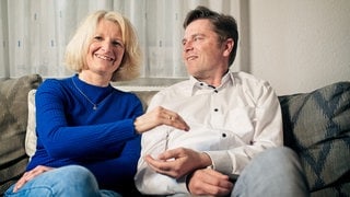 Karin und Matthias sitzen nebeneinander auf der Couch und halten symbolisch eine Hand über- und eine untereinander, weil Karin Matthias eine Niere gespendet hat (Foto: SWR3, SWR3 / Ferdinand Vögele) Karin und Matthias sitzen nebeneinander auf der Couch und halten symbolisch eine Hand über- und eine untereinander, weil Karin Matthias eine Niere gespendet hat