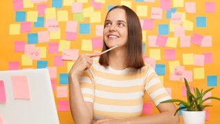 Junge Frau, in Gedanken versunken. Welchen Wunsch hat sie für ihren Beruf?