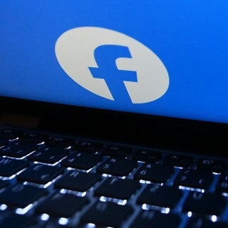 Das Logo von Facebook auf einem fast zugeklapptem Laptop. Verbraucherschützer haben eine Sammelklage gestartet.