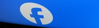 Das Logo von Facebook auf einem fast zugeklapptem Laptop. Verbraucherschützer haben eine Sammelklage gestartet.