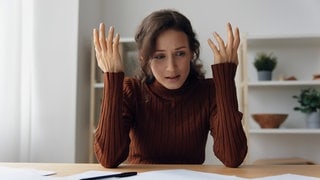 Symbolbild einer Frau die verzweifelt vor einem Mietvertrag sitzt. (Foto: IMAGO, IMAGO / Depositphotos) Symbolbild einer Frau die verzweifelt vor einem Mietvertrag sitzt.