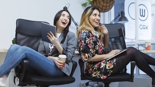 Zwei gutgelaunte Kolleginnen erzählen sich im Büro lustige Sprüche. Das lockert den Büroalltag auf. (Foto: IMAGO, Westend61) Zwei gutgelaunte Kolleginnen erzählen sich im Büro lustige Sprüche. Das lockert den Büroalltag auf.