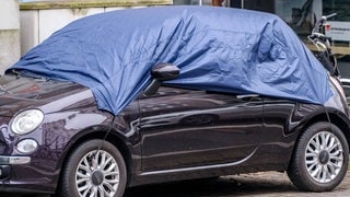Mit einer Abdeckplane als Sonnenschutz wird die Hitze im Auto bekämpft. (Foto: IMAGO, Michael Gstettenbauer) Mit einer Abdeckplane als Sonnenschutz wird die Hitze im Auto bekämpft.