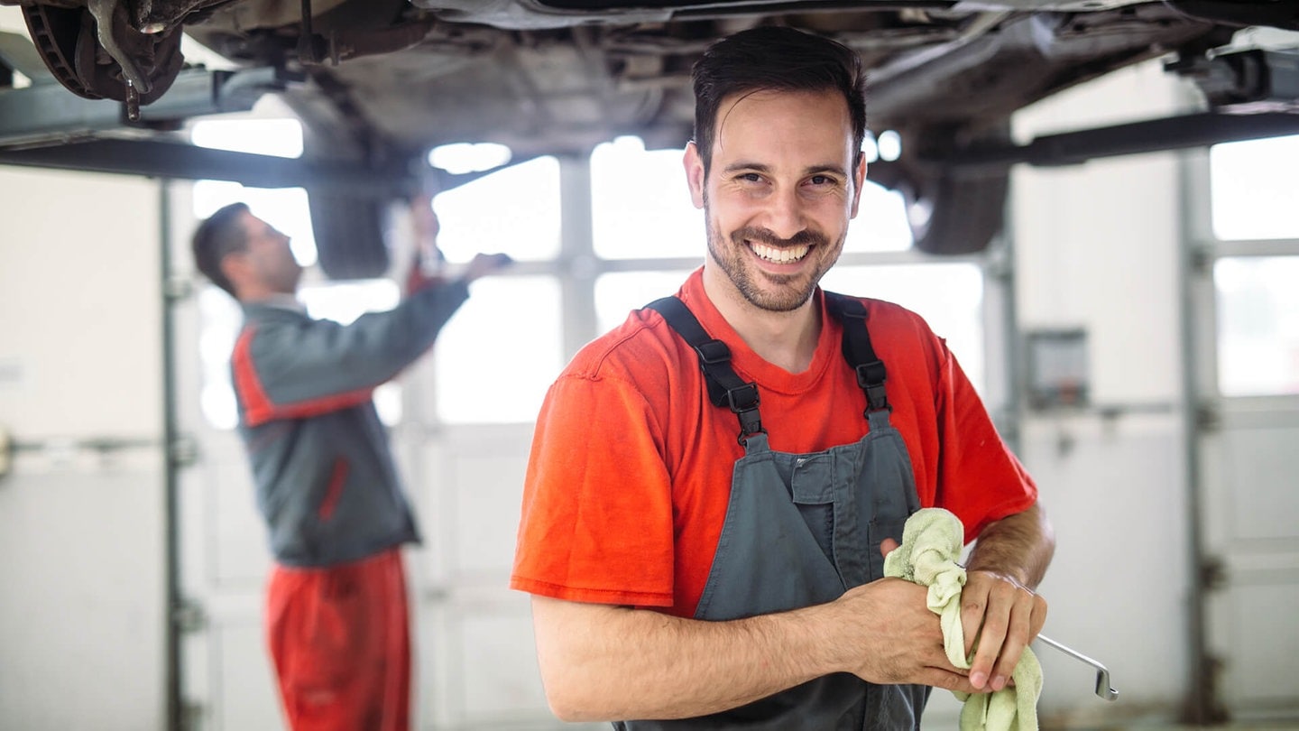 Automechaniker reparieren ein Auto auf der Hebebühne (Foto: Adobe Stock / NDABCREATIVITY)