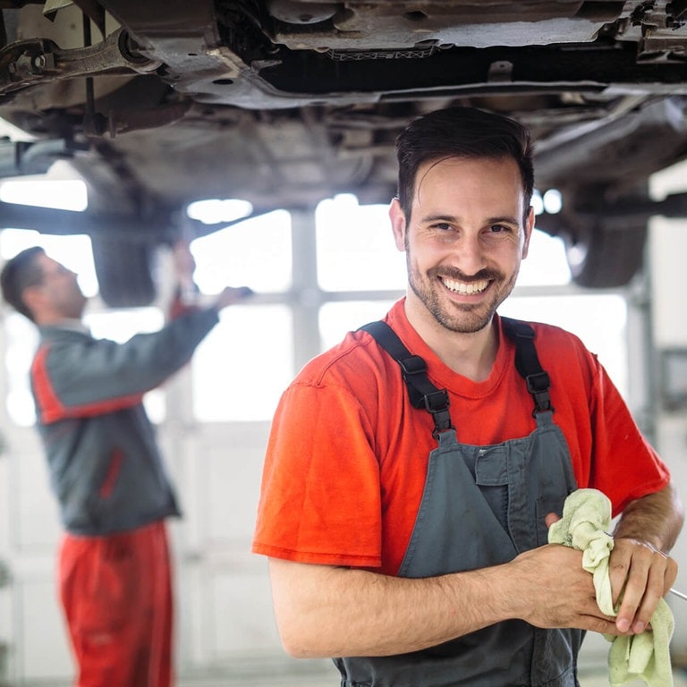 Automechaniker reparieren ein Auto auf der Hebebühne (Foto: Adobe Stock / NDABCREATIVITY)