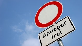 Ein Verkehrzeichen auf dem steht „Anlieger frei“ und das typische Durchfahrt-Verboten-Schild vor blauem Himmel. Was bedeutet aber genau Anlieger frei? 