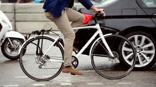 Radfahrer, der von einem Auto überholt wird
