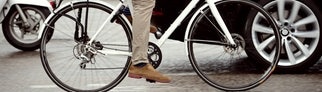 Radfahrer, der von einem Auto überholt wird