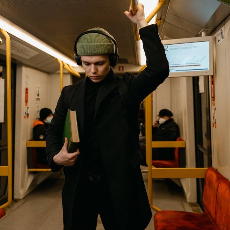 Mann in Bahn mit Buch (Foto: Mart Production | Pexels)