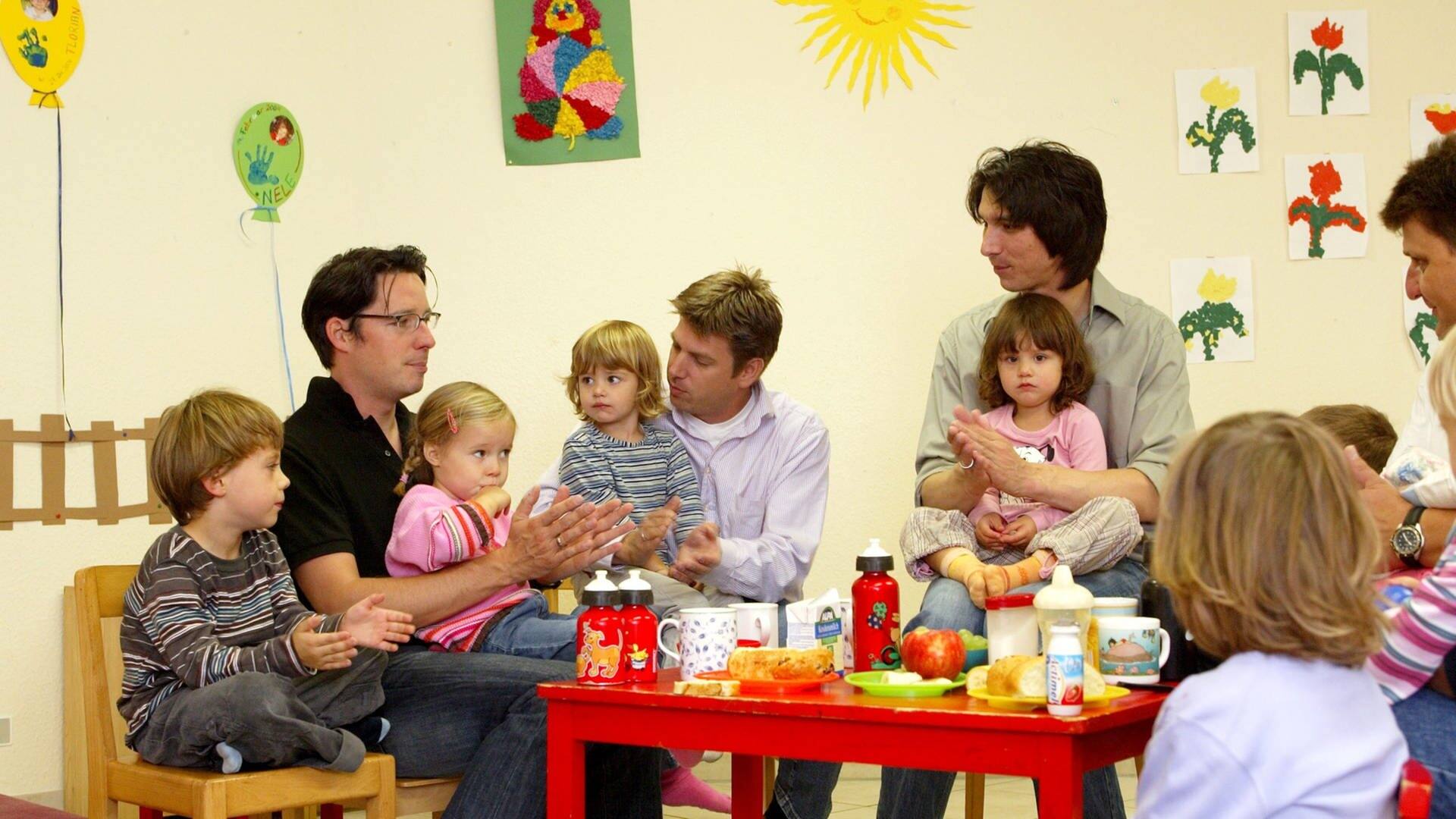 Väter sitzen mit ihren Kindern an einem Kindertisch in einer Krabbelgruppe (Foto: picture-alliance / Reportdienste, picture alliance / JOKER | Petra Steuer)