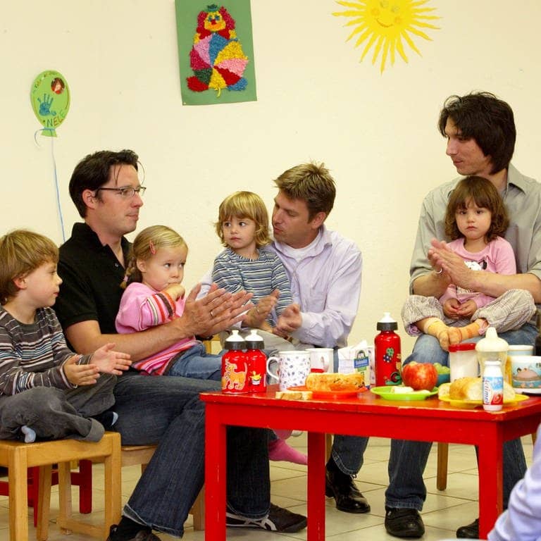 Väter sitzen mit ihren Kindern an einem Kindertisch in einer Krabbelgruppe (Foto: picture-alliance / Reportdienste, picture alliance / JOKER | Petra Steuer)