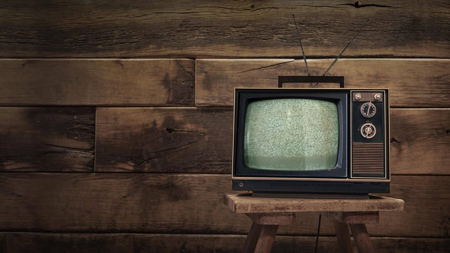 Ein altes Fernsehgerät steht vor einer holzvertäfelten Wand und ist ein Symbol fürs Älterwerden (Foto: picture-alliance / Reportdienste, picture alliance / Zoonar | Marco Martins)