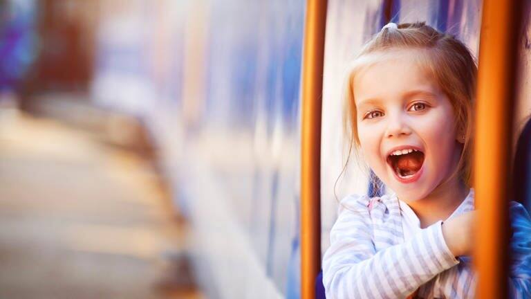 Ein Mädchen schaut aus einem Zug und hat den Mund offen
