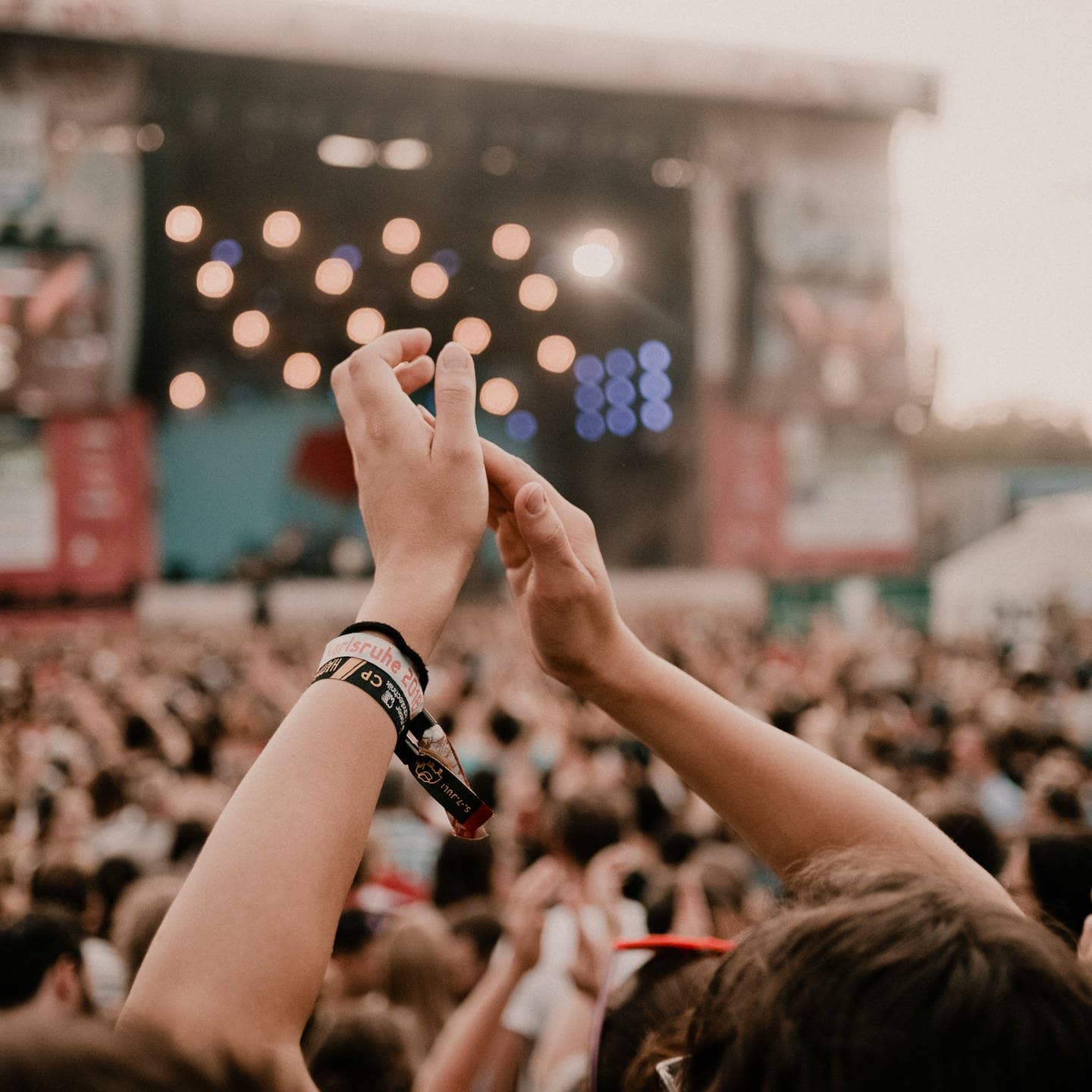 Hände klatschen im Vordergund, Bühne und Publikum im Hintergrund (Foto: Niko Neithardt)