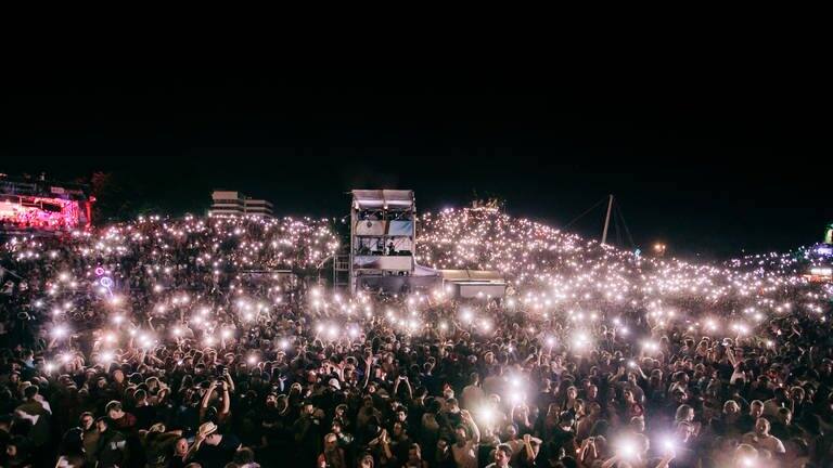 Publikum bei Nacht hält Lampen hoch (Foto: Niko Neithardt)