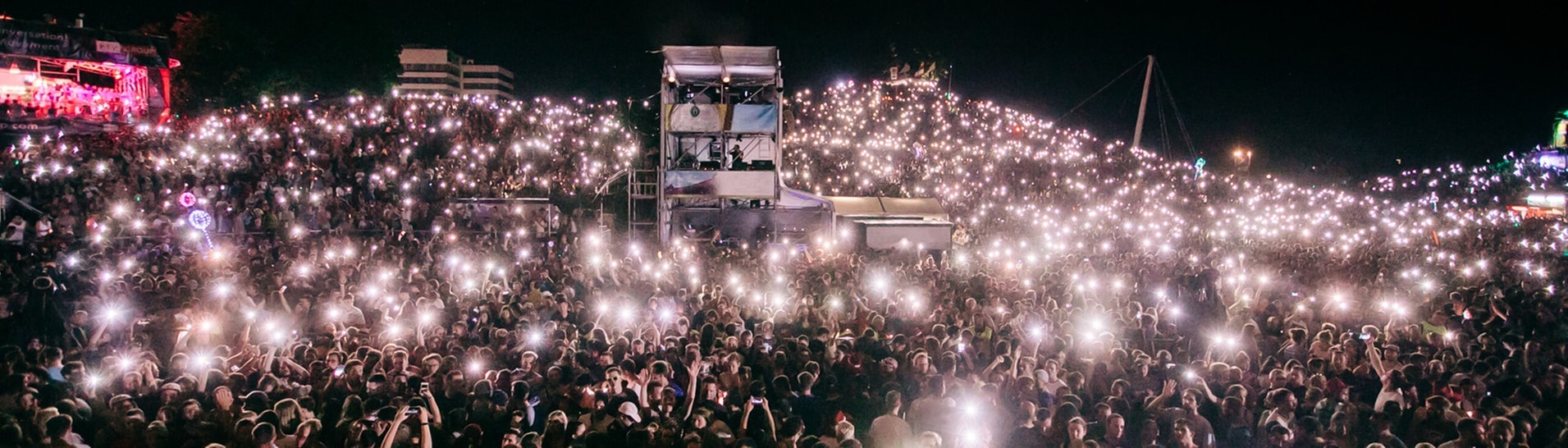 Publikum bei Nacht hält Lampen hoch (Foto: Niko Neithardt)