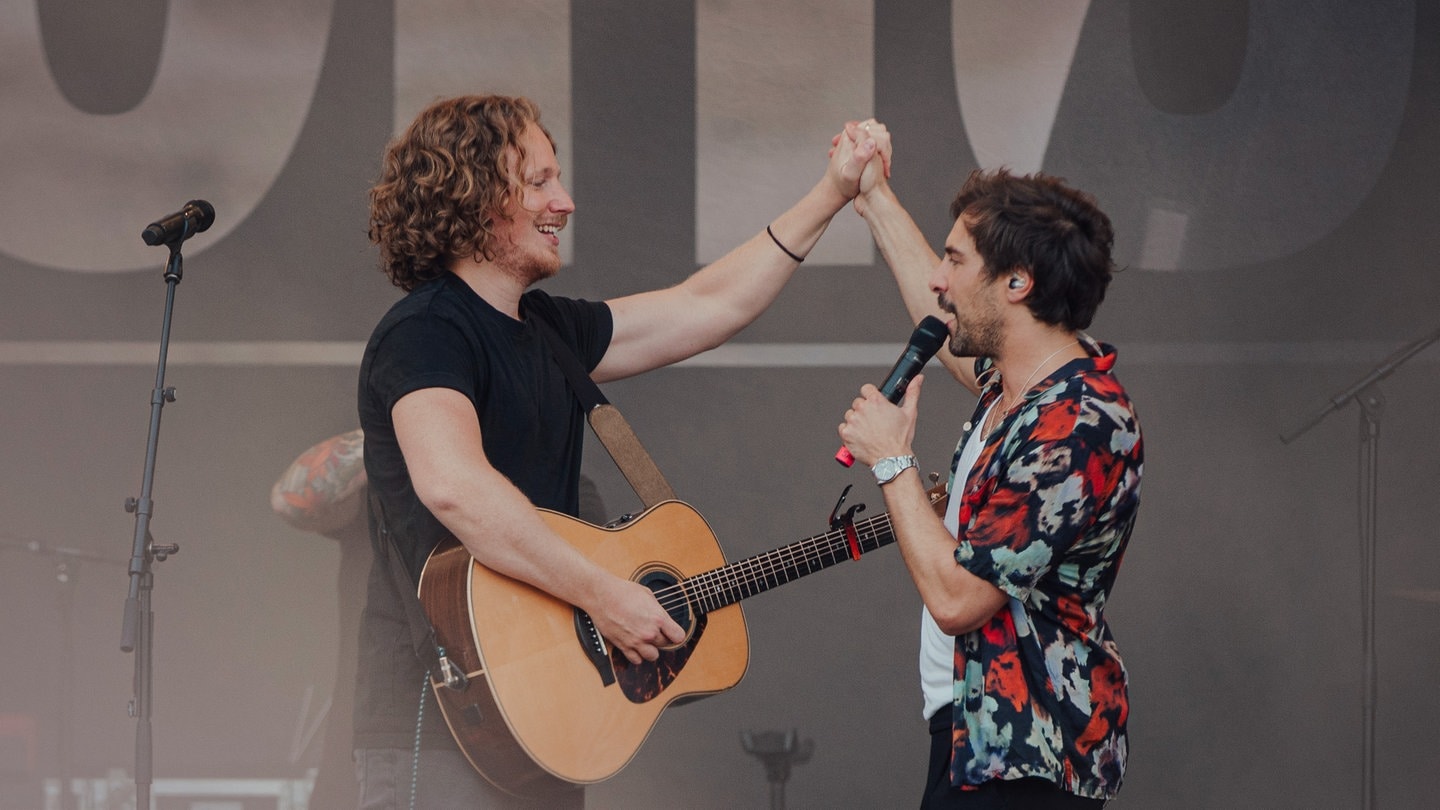 Michael Schulte und Max Giesinger klatschen sich auf der Bühne ab. (Foto: SWR3, Ronny Zimmermann)