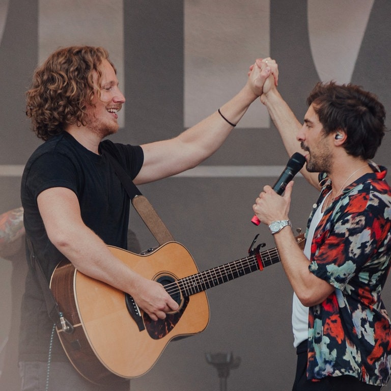 Michael Schulte und Max Giesinger klatschen sich auf der Bühne ab. (Foto: SWR3, Ronny Zimmermann)