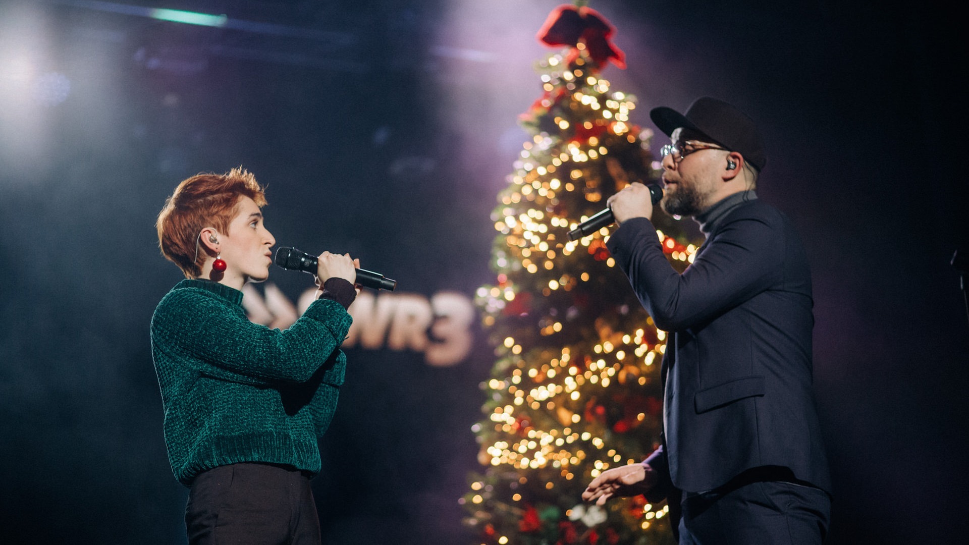 Foto: SWR3, SWR3/Niko Neithardt Anny Ogrezeanu, Gewinnerin der 12. Staffel "The Voice of Germany" mit Mark Forster, singend auf der Bühne vor beleuchtetem Weihnachtsbaum (Foto: SWR3, SWR3/Niko Neithardt)
