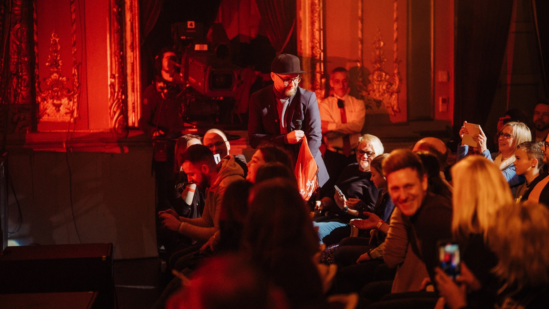 Foto: SWR3, SWR3/Niko Neithardt Mark Forster läuft in einem Konzertsaal durchs Publikum mit einer Tüte in der Hand und verteilt Bonbons an die Besucher (Foto: SWR3, SWR3/Niko Neithardt)