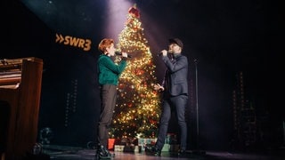 Anny Ogrezeanu, Gewinnerin der 12. Staffel "The Voice of Germany" mit Mark Forster, singend auf der Bühne vor beleuchtetem Weihnachtsbaum (Foto: SWR3, SWR3/Niko Neithardt) Anny Ogrezeanu, Gewinnerin der 12. Staffel "The Voice of Germany" mit Mark Forster, singend auf der Bühne vor beleuchtetem Weihnachtsbaum