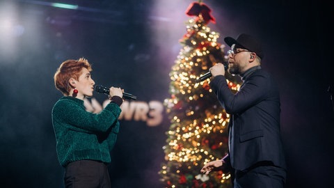 Anny Ogrezeanu, Gewinnerin der 12. Staffel "The Voice of Germany" mit Mark Forster, singend auf der Bühne vor beleuchtetem Weihnachtsbaum (Foto: SWR3, SWR3/Niko Neithardt) Anny Ogrezeanu, Gewinnerin der 12. Staffel "The Voice of Germany" mit Mark Forster, singend auf der Bühne vor beleuchtetem Weihnachtsbaum
