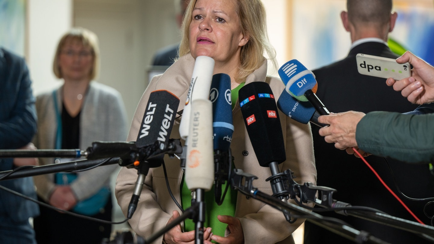 Foto: dpa Bildfunk, picture alliance/dpa | Monika Skolimowska Bundesinnenministerin Nancy Faeser steht vor Reportern und spricht. Viele Mikrofone sind vor ihr aufgebaut. (Foto: dpa Bildfunk, picture alliance/dpa | Monika Skolimowska)