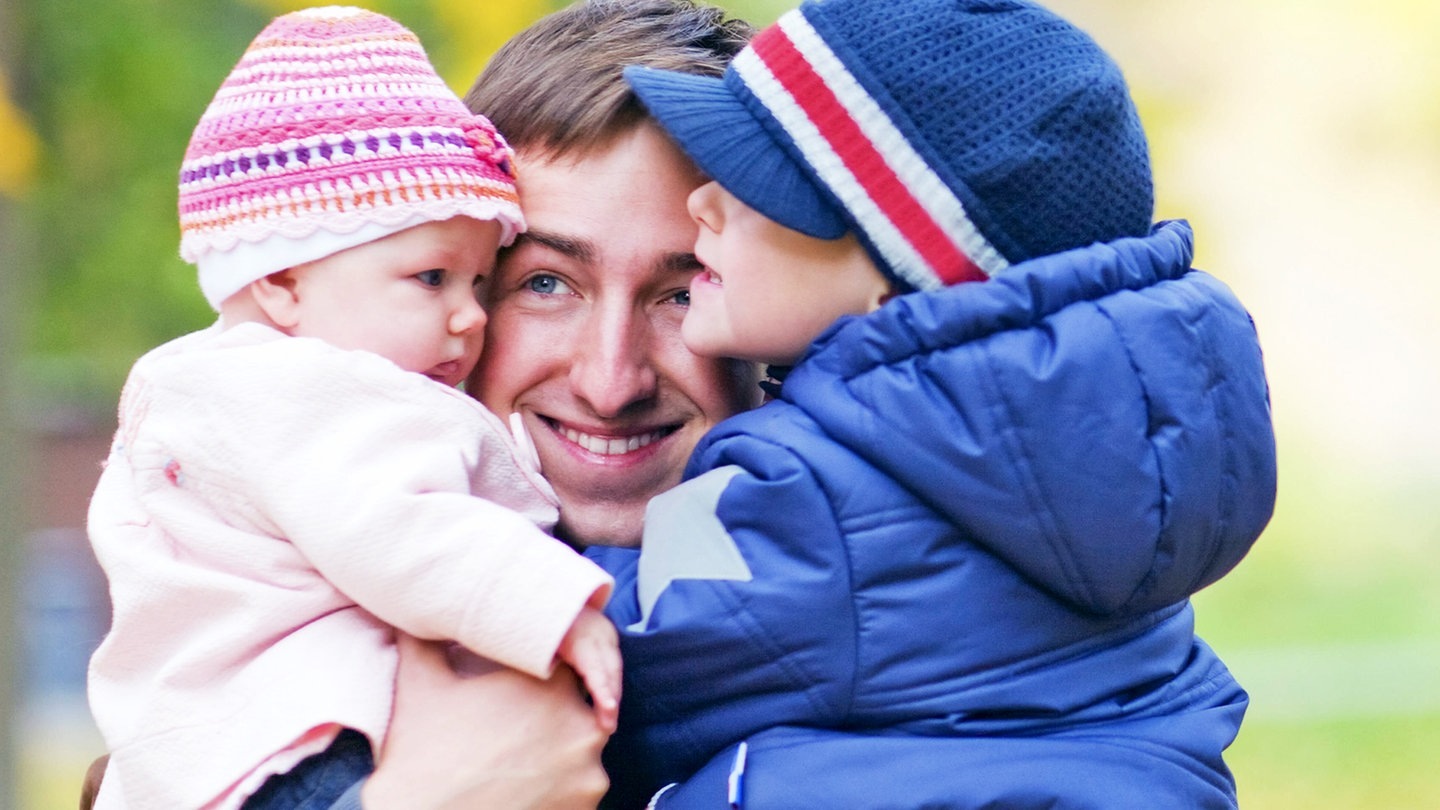 Ein Vater mit zwei Kindern auf dem Arm (Foto: picture-alliance / Reportdienste, McPHOTO)