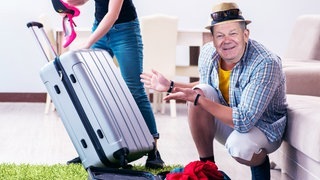 Olaf Scholz neben gepacktem Koffer