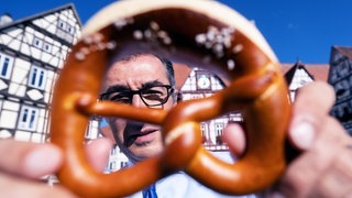 Cem Özdemir hält eine Brezel