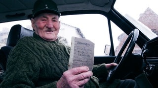 Rentner am Steuer zeigt stolz seinen alten Führerschein