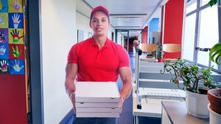 Pizzalieferant steht in Schulflur