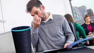 Alexa sitzt im Jobcenter vor Beamten