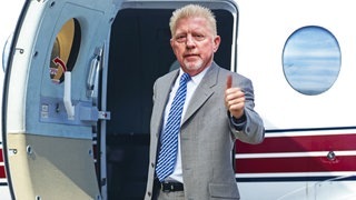 Boris Becker zeigt Daumen hoch vor Flugzeugtür